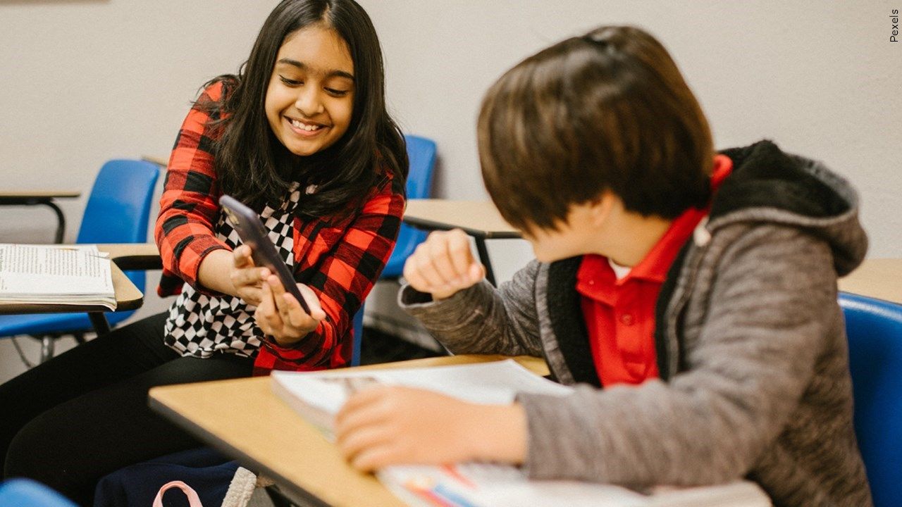 Two students looking at a cell phone screen