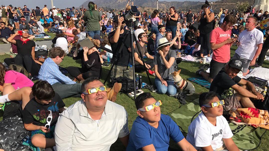 Solar eclipse fans watch the moon partially obscure the sun Monday, Aug. 21, 2017, at Griffith Observatory in Los Angeles